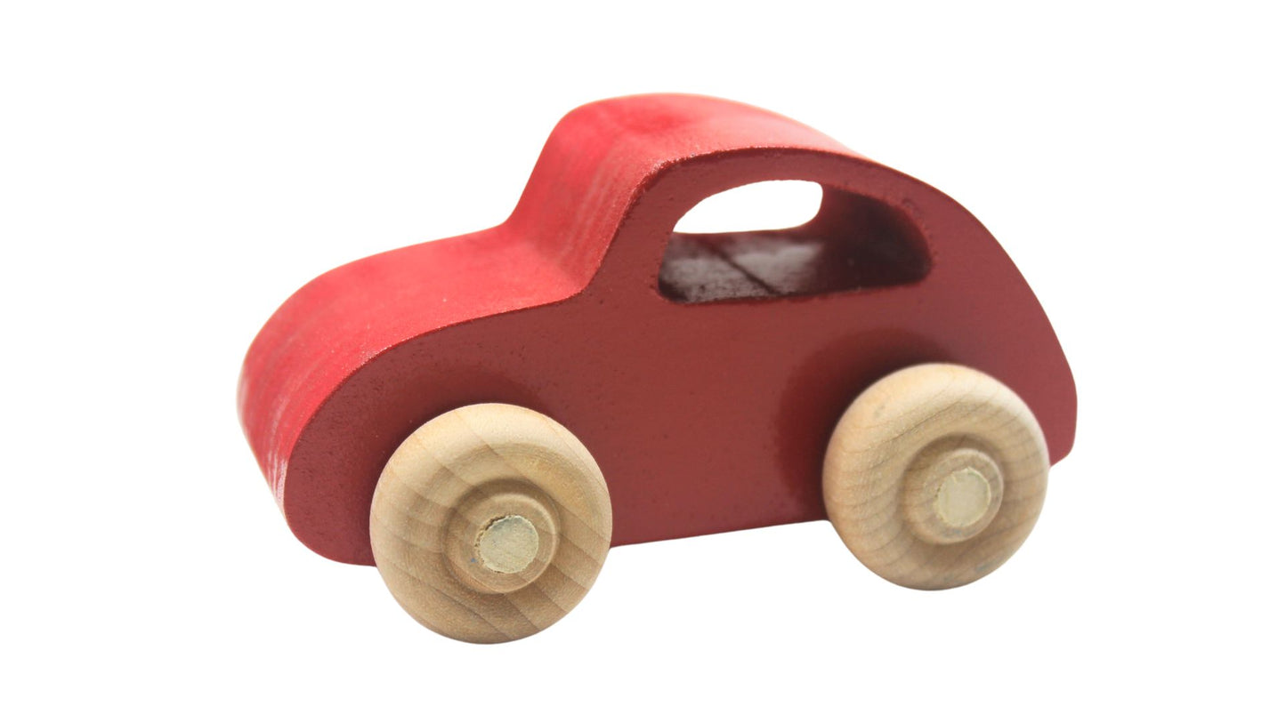 Volkswagen car carrier solid wood toy. Set includes a tractor with separate trailer, a VW bug, convertible, and van, and two people
