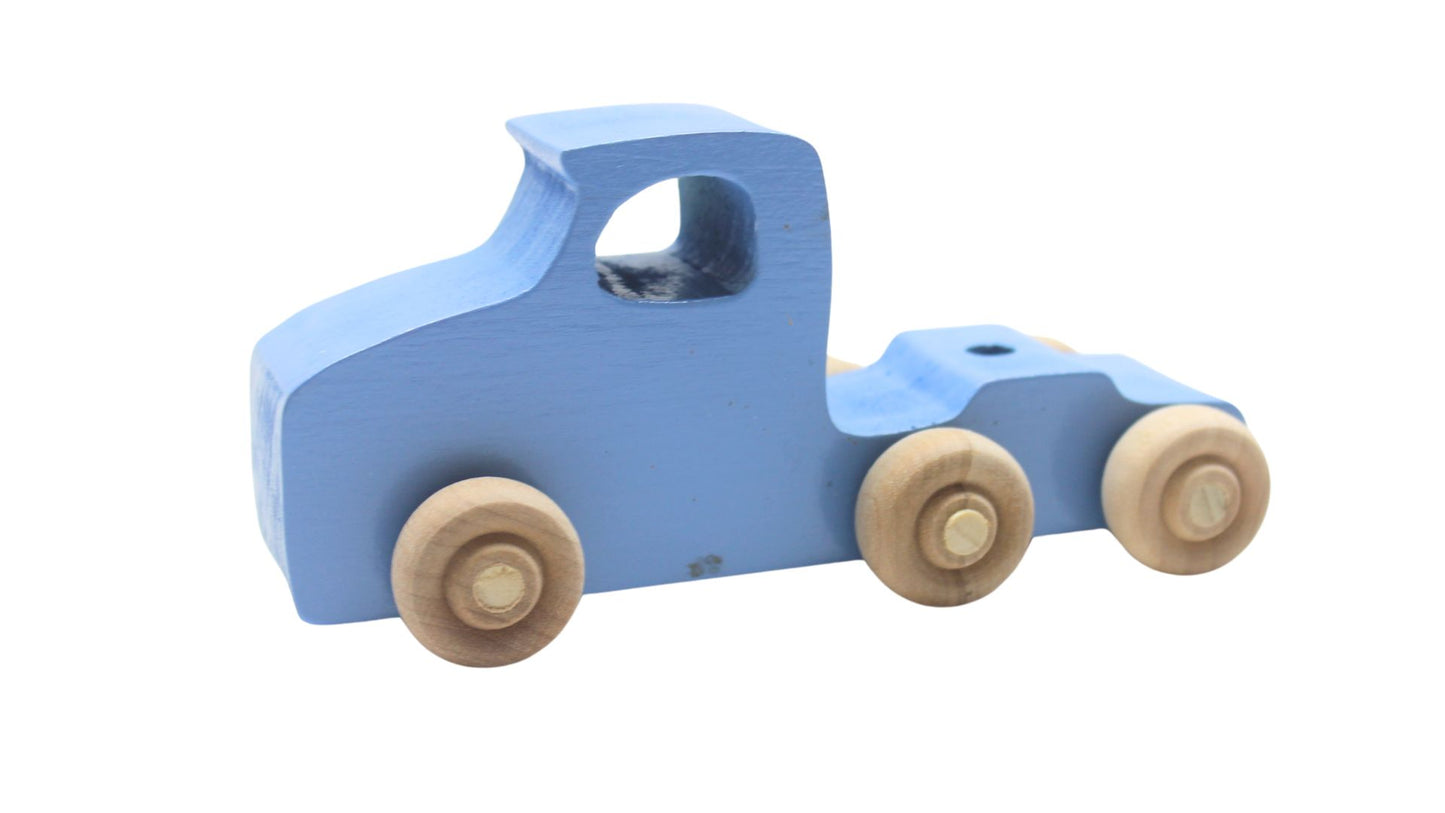 Volkswagen car carrier solid wood toy. Set includes a tractor with separate trailer, a VW bug, convertible, and van, and two people