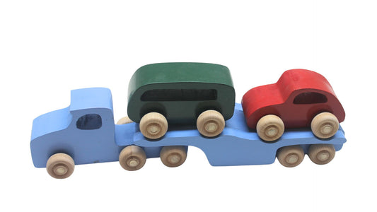 Volkswagen car carrier solid wood toy. Set includes a tractor with separate trailer, a VW bug, convertible, and van, and two people