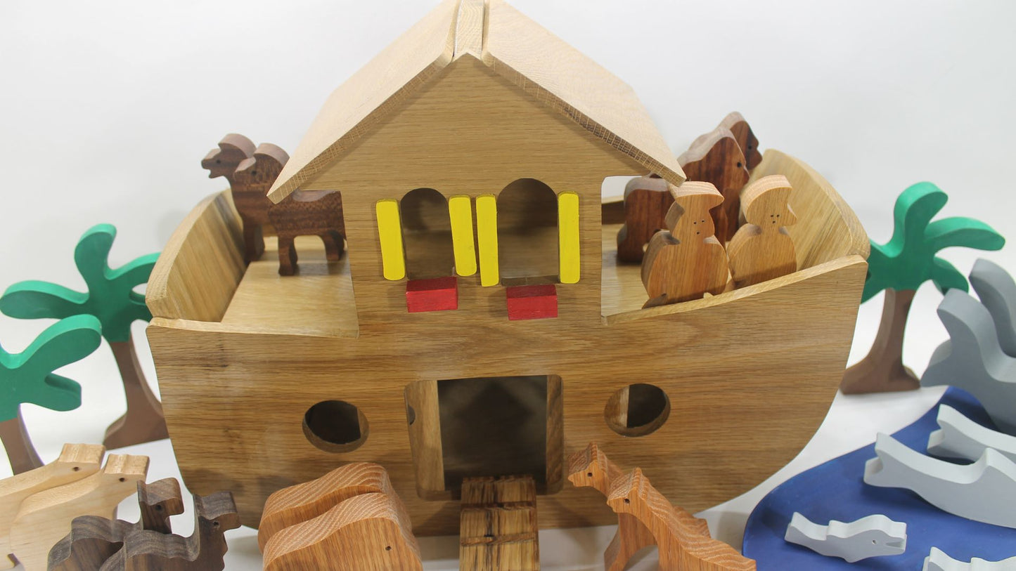 Handcrafted wood Noah's ark with 11 pairs of animals. A ramp leads to the sliding doors in the ark's side for the animals to enter.